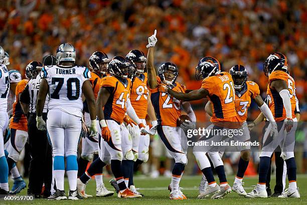Cornerback Chris Harris of the Denver Broncos celebrates as he intercepts a pass thrown by quarterback Cam Newton of the Carolina Panthers in the...
