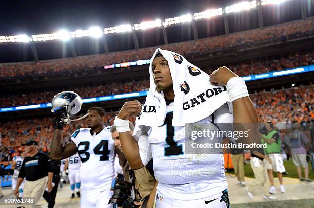 Quarterback Cam Newton of the Carolina Panthers walks off the field after the Panthers lose to the Denver Broncos 21-20 at Sports Authority Field at...