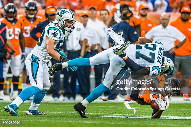Carolina Panthers cornerback Robert McClain tackles Denver Broncos wide receiver Emmanuel Sanders at Sports Authority Field at Mile High in Denver on...