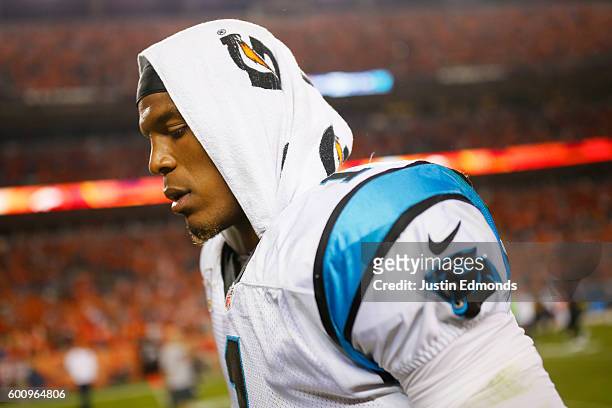Quarterback Cam Newton of the Carolina Panthers walks off the field after losing to the Broncos 21-20 at Sports Authority Field at Mile High on...