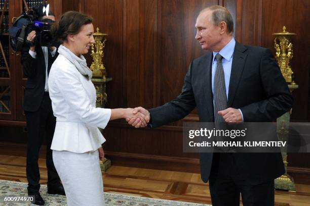Russian President Vladimir Putin shakes hands with the newly-appointed Russia's children's rights ombudswoman Anna Kuznetsova during a meeting at the...