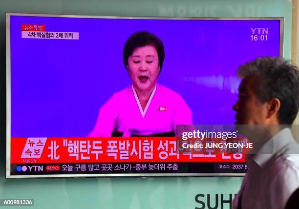 Man walks past a television news broadcast at a railway station in Seoul on September 9, 2016 showing a North Korean anchor announcing the country's...