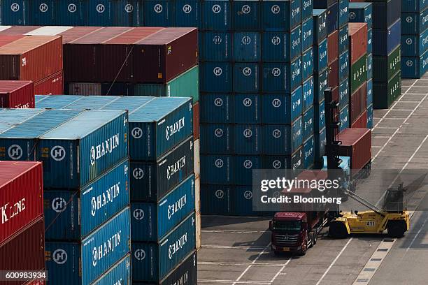 Reach stacker unloads a shipping container from a truck at the Hanjin Newport Co. Terminal, a unit of Hanjin Group, at Busan New Port in Busan, South...