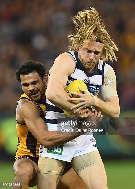 Cameron Guthrie of the Cats is tackled by Cyril Rioli of the Hawks during the 2nd AFL Qualifying Final match between the Geelong Cats and the...