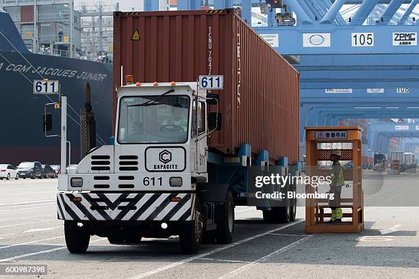Worker inspects a truck carrying a shipping container at a container terminal at Busan New Port in Busan, South Korea, on Friday, Sept. 9, 2016. With...