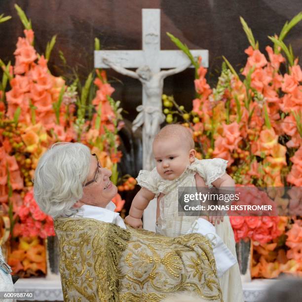 Arch Bishop Antje Jackelen holds up Prince Alexander at Palace Chapel in Drottningholm Palace in Stockholm during the christening of the five...