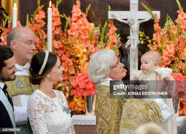 Arch Bishop Antje Jackelen holds up Prince Alexander at Palace Chapel in Drottningholm Palace in Stockholm while Prince Carl Philip , Bishop Johan...