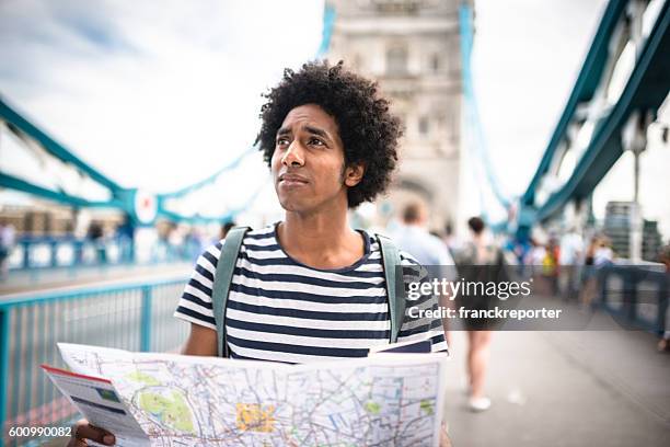 solo traveler in tower bridge area reading a map - lost stock pictures, royalty-free photos & images
