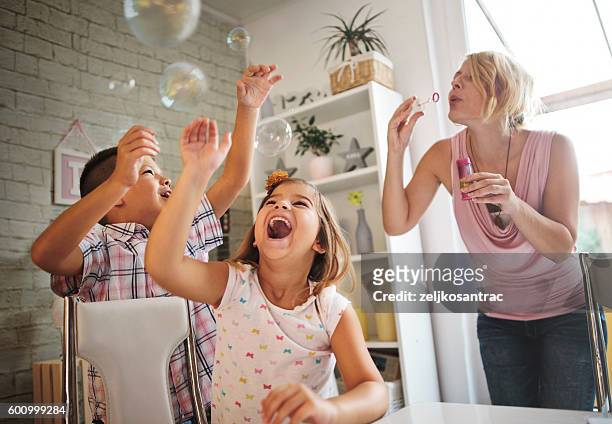 mother and daughter having fun - blowing bubbles stock pictures, royalty-free photos & images