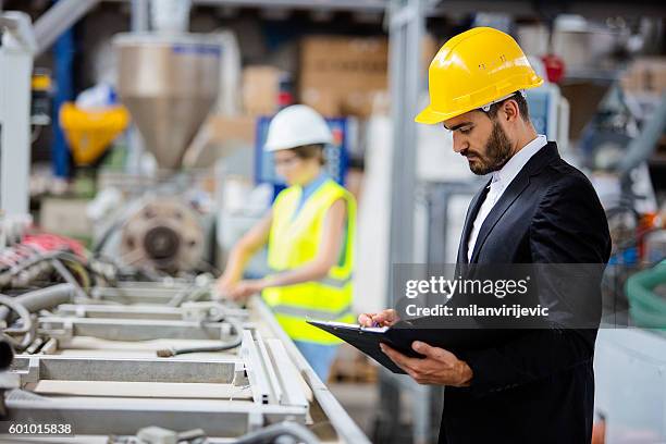 junge qualitätsinspektor-prüflinie - person in suit construction stock-fotos und bilder