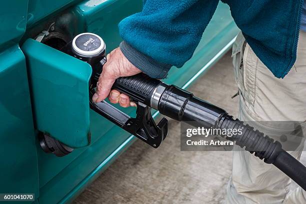 Close up of man pumping diesel fuel into his vehicle at service station.