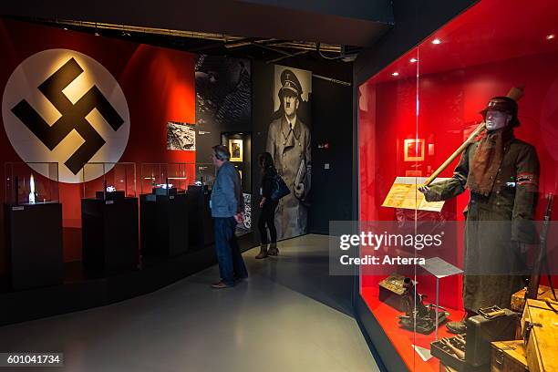 Tourists with audio guides visiting the Bastogne War Museum devoted to the Second World War Two Battle of the Bulge in the Belgian Ardennes, Belgium.