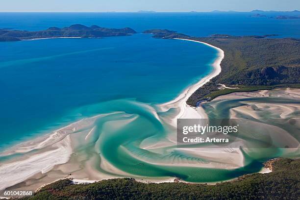 Areal view of white sandy beaches and turquoise blue water of Whitehaven Beach on Whitsunday Island in the Coral Sea, Queensland, Australia.