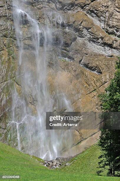 Tourists in rock face enjoying the 300m high Staubbach Falls at Lauterbrunnen in the Bernese Oberland, Swiss Alps, Switzerland.