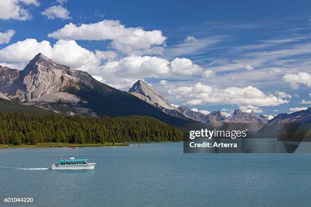 Canoes and tourist boat on Maligne Lake in the Jasper National Park, Alberta, Canadian Rockies, Canada.