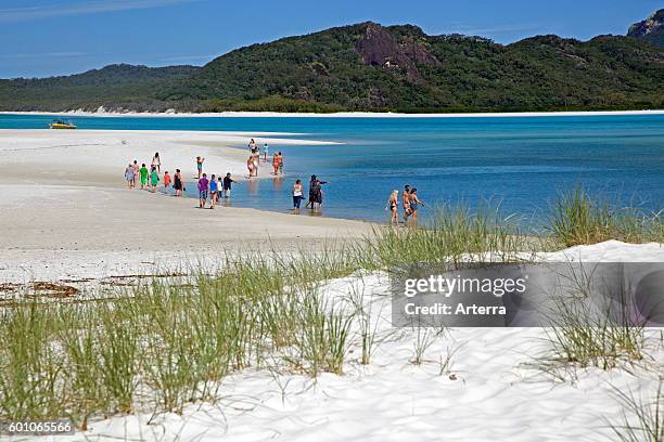 Tourists visiting the shoreline of Whitehaven Beach on Whitsunday Island in the Coral Sea, Queensland, Australia.