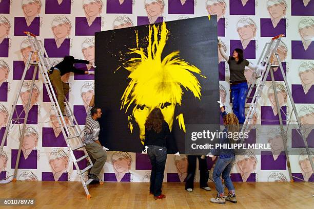 Workers prepare to hang an self-portrait of American artist Andy Warhol 26 January 2005 in the Lyon Contemporary Art Museum. "The Late Work", on...