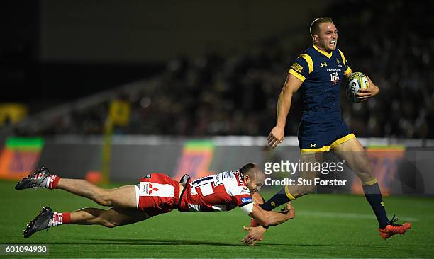 Warriors player Perry Humphreys breaks the tackle of Charlie Sharples of Gloucester on his way to scoring a try during the Aviva Premiership match...