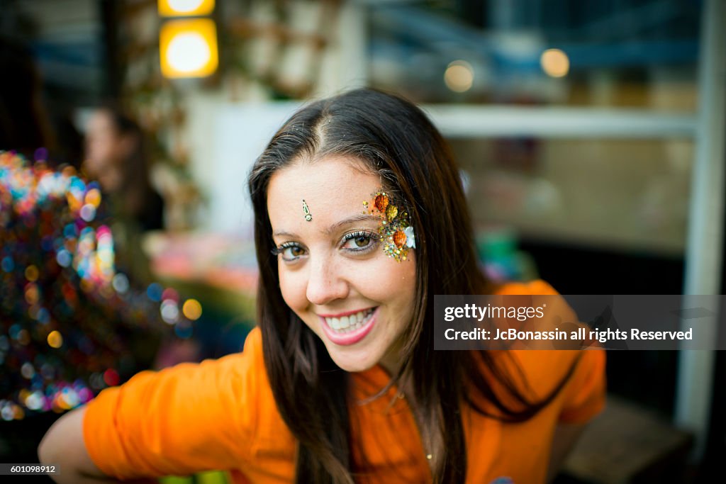 Woman with glitter on her face smiling