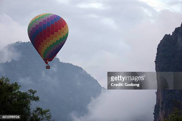 Vientiane Province. Rainy season. Mountain, black clouds and hot air balloon. Vang Vieng, Laos.