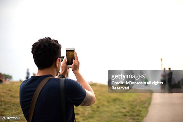latin man taking a picture - jc bonassin stockfoto's en -beelden