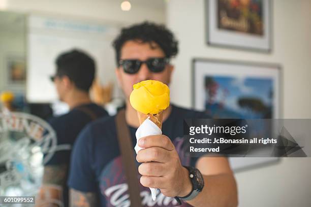 latin man with an icecream - jc bonassin stock-fotos und bilder