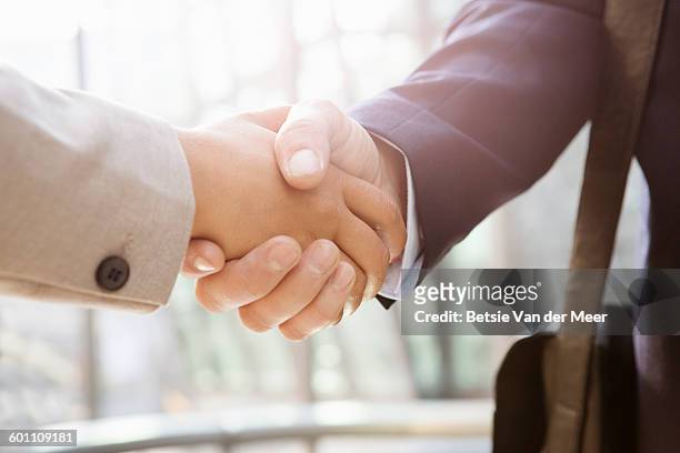 businessman shakes hand of businesswoman, close up - deal england - fotografias e filmes do acervo