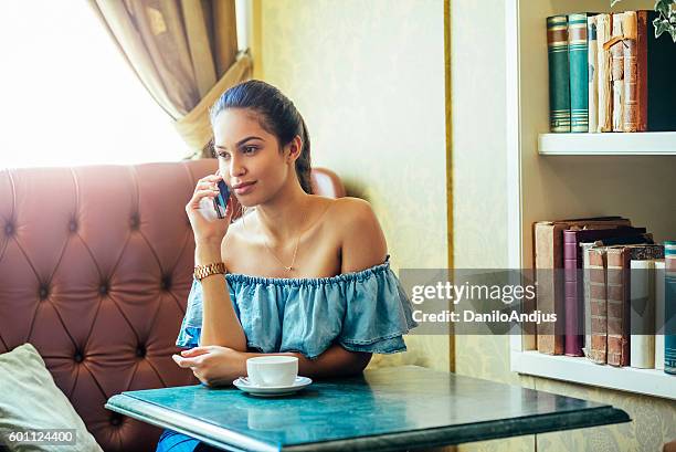 gorgeous woman talking on the phone in a nice bar - bar drink establishment stock pictures, royalty-free photos & images