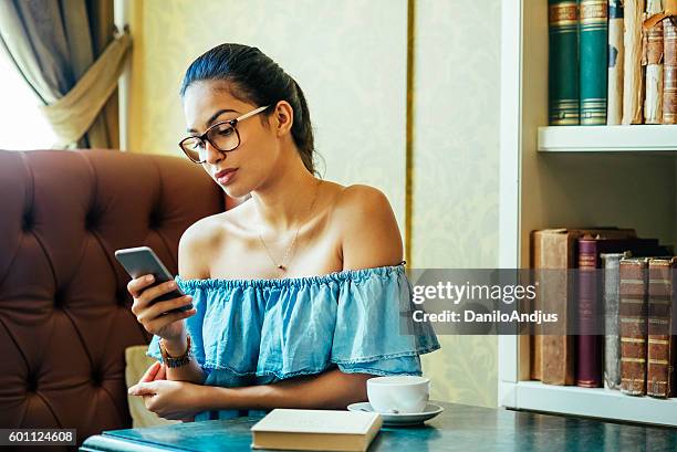 young woman using her smart phone - bar drink establishment stock pictures, royalty-free photos & images