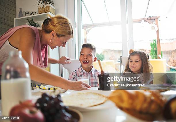 happy mother and kids having breakfast in kitchen - mother son milk imagens e fotografias de stock