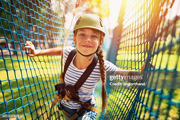 teenage girl having fun in ropes course adventure park - zip line stockfoto's en -beelden