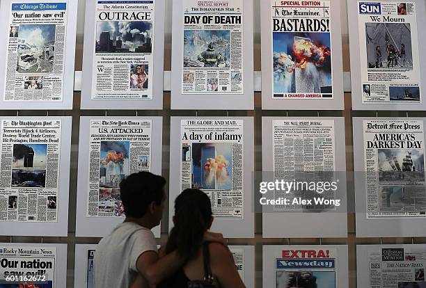 Visitors browse newspaper front pages with the story of the 9/11 terror attacks at the 9/11 Gallery of the Newseum on September 9, 2016 in...