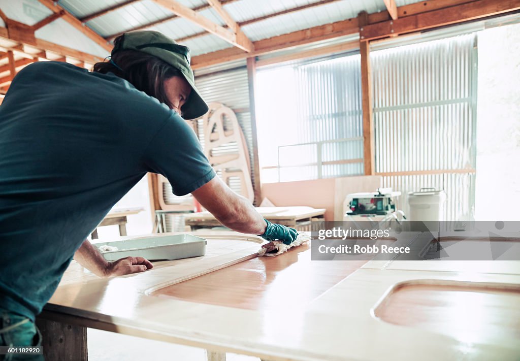 An adult, male carpenter working in his wood shop