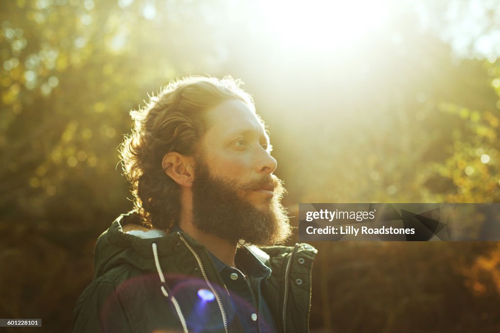 Man standing in sunlight in forest