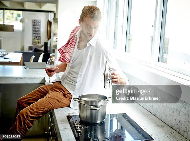 man cooks pasta at home - burner stove top stock pictures, royalty-free photos & images