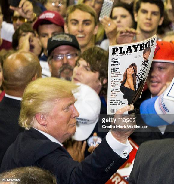Republican Presidential candidate Donald Trump autographs a Playboy Magazine for a supporter after his rally at the Pensacola Bay Center on September...