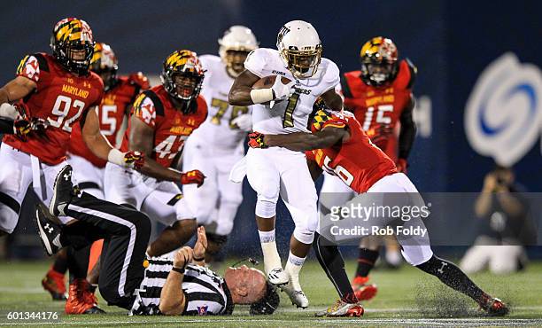 Alex Gardner of the FIU Panthers knocks over an official as he is hit by Milan Barry-Pollock of the Maryland Terrapins at FIU Stadium on September 9,...