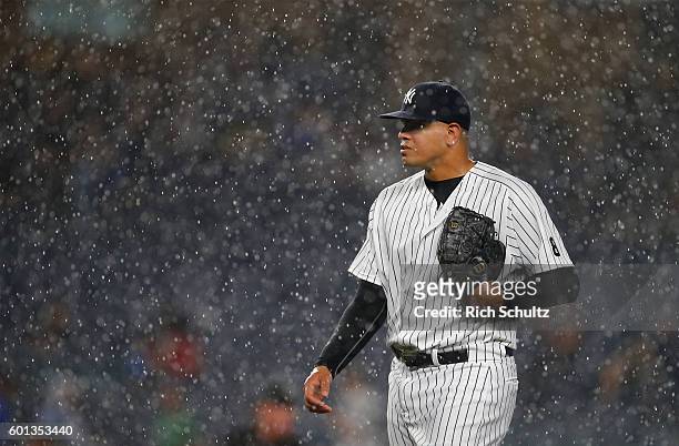 Pitcher Dellin Betances of the New York Yankees walks off the mound as rain pours down causing a rain delay in the ninth inning of a game against the...