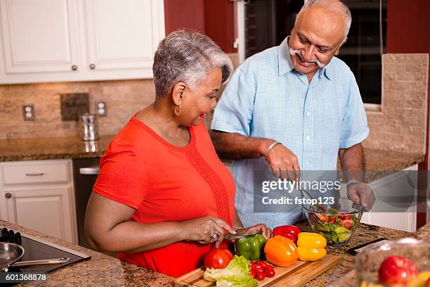 ホームキッチンで一緒に料理幸せなシニア大人のカップル。 - middle aged couple cooking ストックフォトと画像