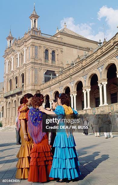 Young women in traditional costumes in the Plaza de Espana during the Feria de Abril , Seville, Andalusia, Spain.