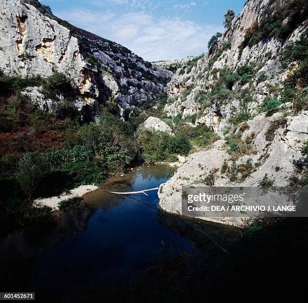 Waterway between the rocks near the Rocky Necropolis of Pantalica, Pantalica Nature Reserve, Cava Grande torrent valley and the Anapo river valley,...
