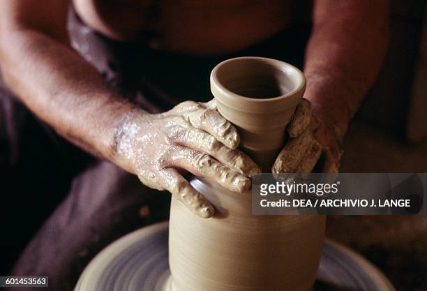 An artisan shaping a vase on the lathe, Grottaglie, Apulia, Italy.