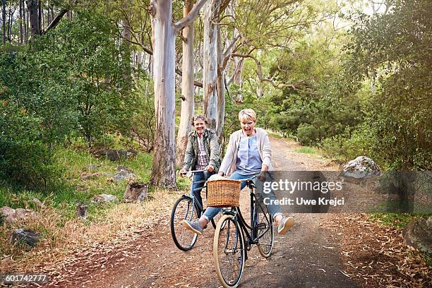 senior couple riding bicycles - candid mature couple outdoors stock-fotos und bilder