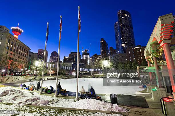 people enjoy ice rink at night in downtown city - downtown calgary stock pictures, royalty-free photos & images