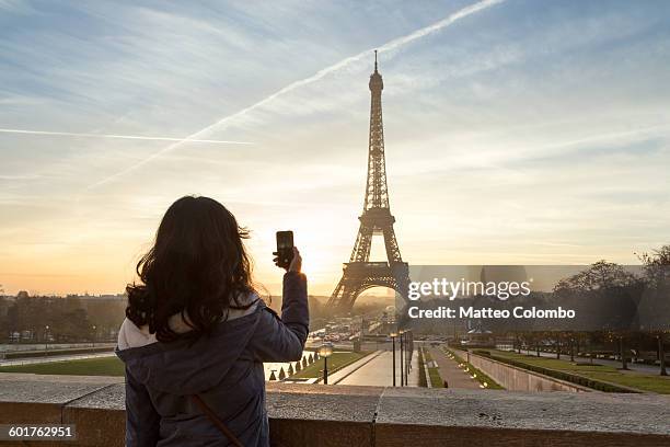 woman photographing the eiffel tower, paris - eiffel tower paris france stock pictures, royalty-free photos & images