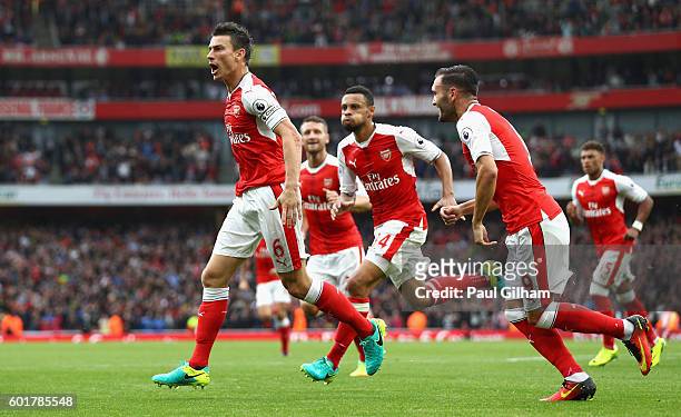 Laurent Koscielny of Arsenal celebrates scoring his sides first goal with his team mates during the Premier League match between Arsenal and...