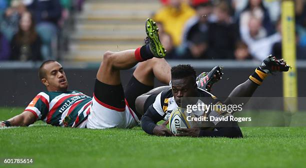 Christian Wade of Wasps beats Peter Betham to the ball to score the first try of the match during the Aviva Premiership match between Leicester...