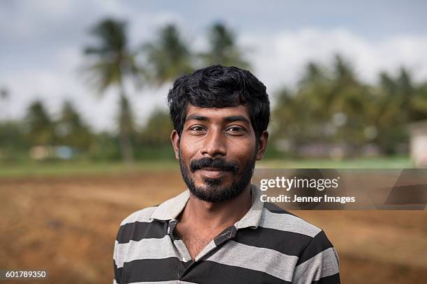 happy indian farmer standing in a field. - farmer portrait stock pictures, royalty-free photos & images