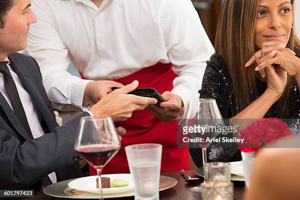 businessman paying check at restaurant - restaurant bill stock-fotos und bilder