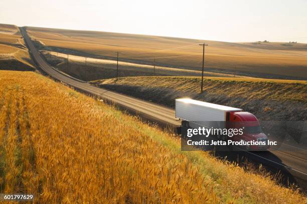 truck driving on remote road - truck highway stock-fotos und bilder